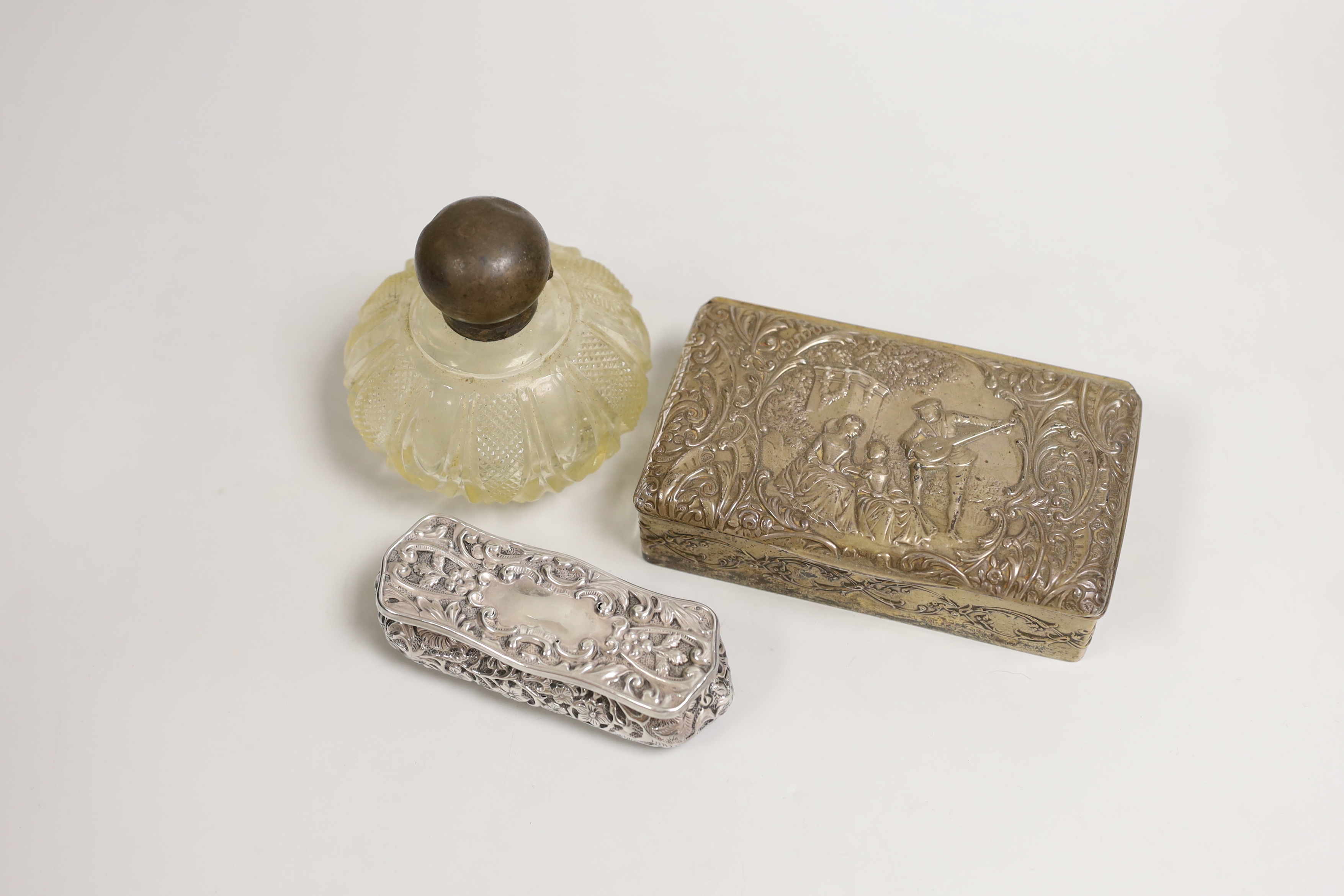 An Edwardian repousse silver mounted trinket box, Birmingham, 1904, 13.8cm, one other smaller repousse box and a silver topped glass scent bottle.